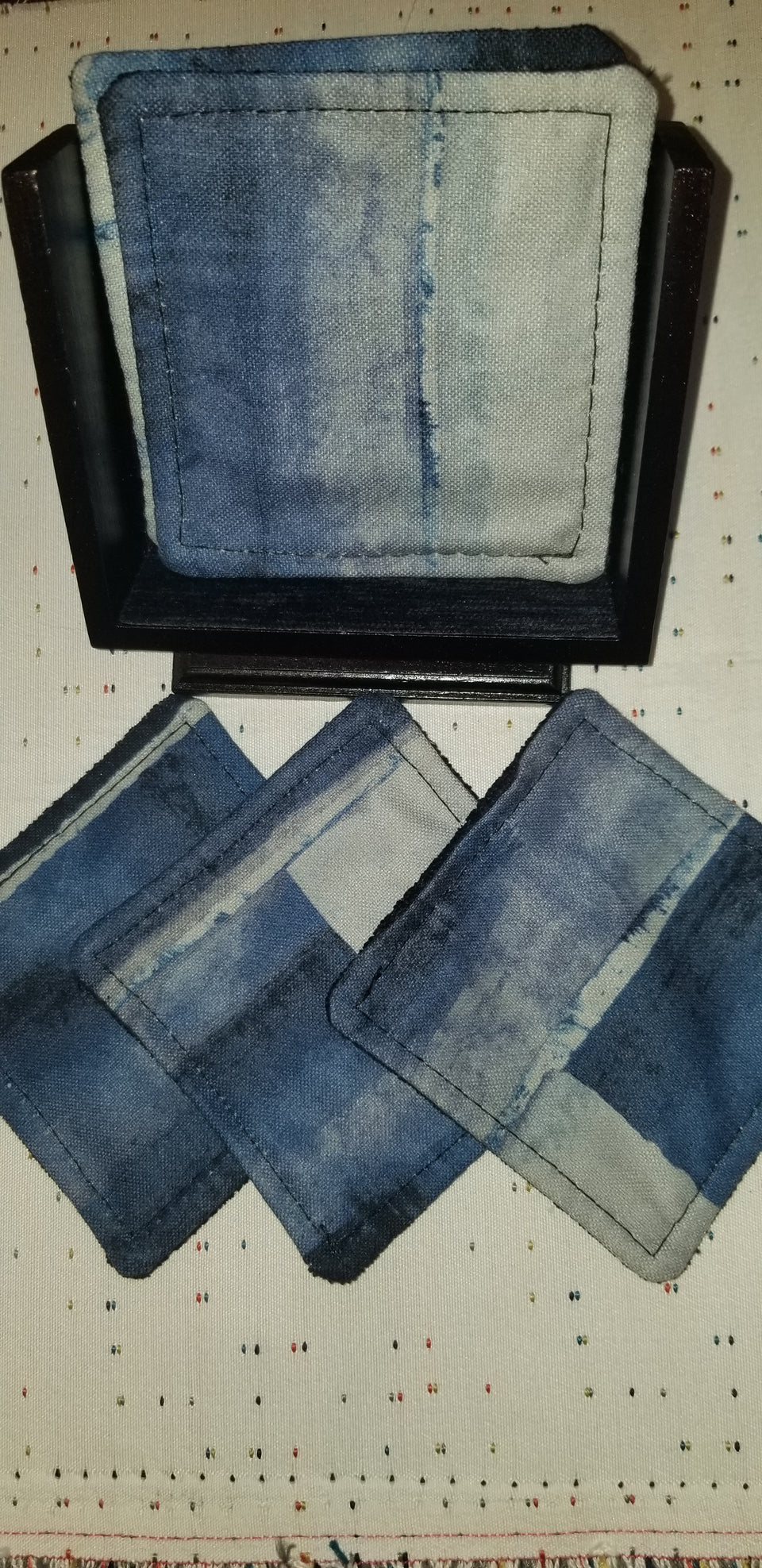 modern walnut pedestal coaster holder with classic blue, navy blue, and gray watercolor patterned coasters
