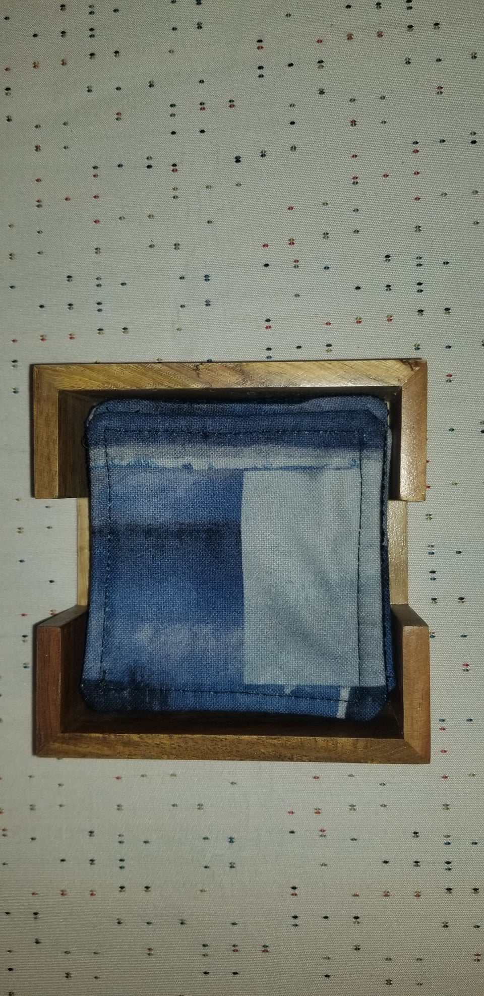 Modern square acacia wood coaster holder with blue velour lining and Chase blue and gray matching coasters. Top view detail.