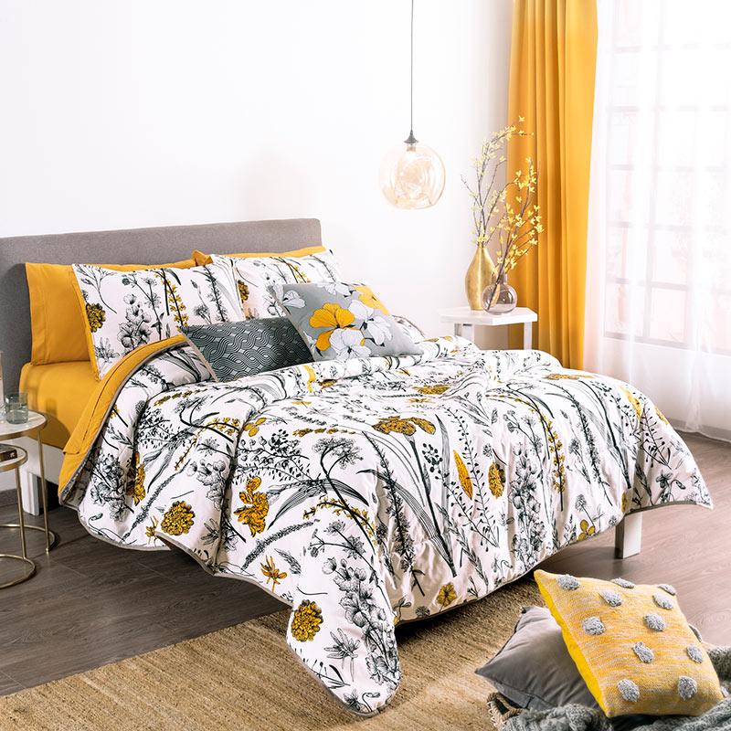 modern bedroom with yellow, black, & white floral reversible comforter set angleview