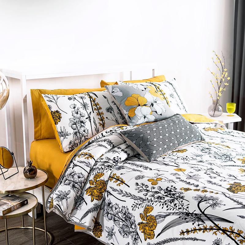 modern bedroom with yellow, black, & white floral reversible comforter set side view detail