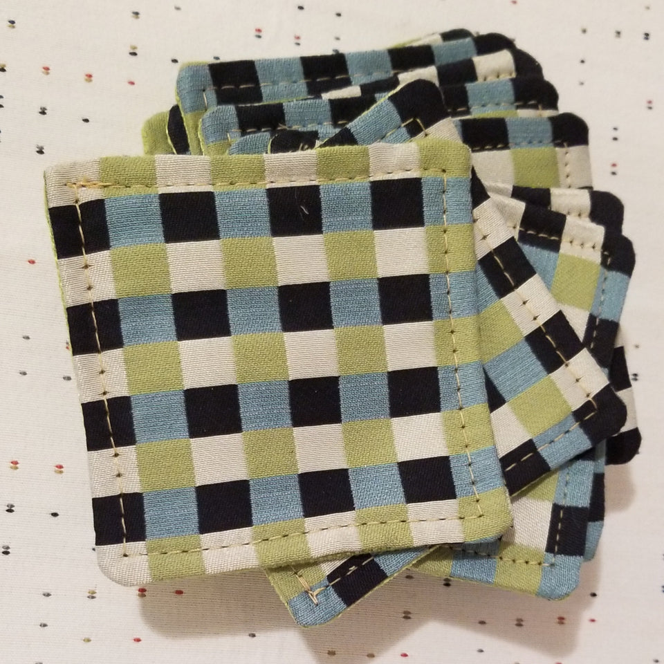 Stack of Chuck black, white, lime green, and turquoise gingham check patterned coasters detail top view.