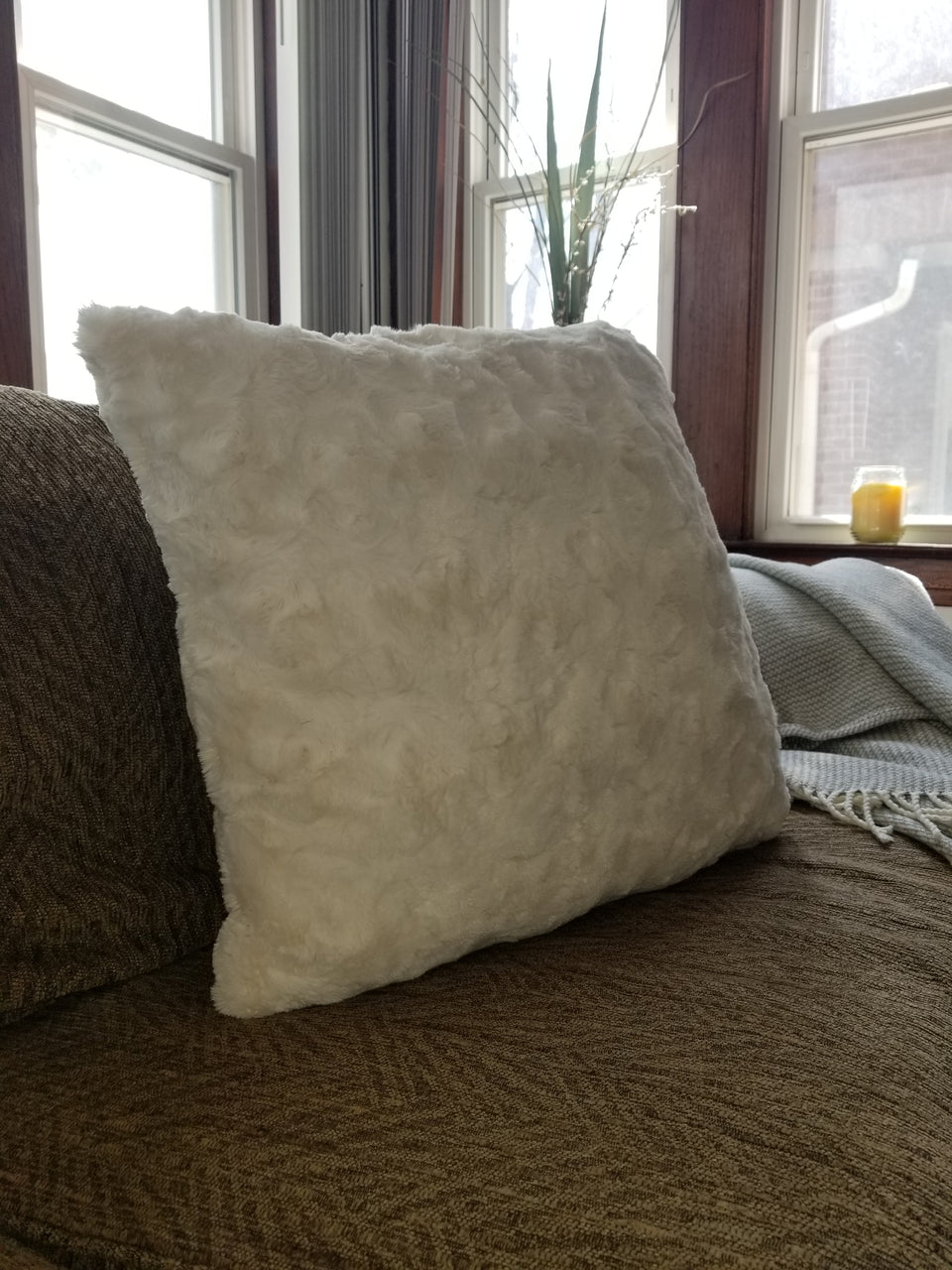 soft faux fur throw pillow cover on tan couch with taupe throw cover