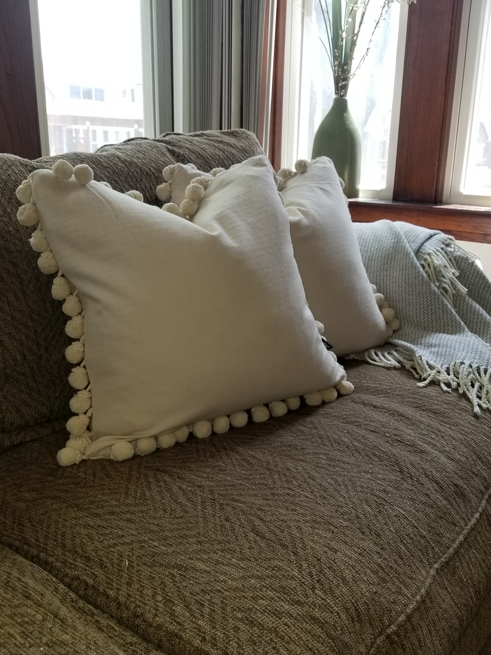 18 x 18 cream pom pom pillow covers on brown couch with beige throw cover