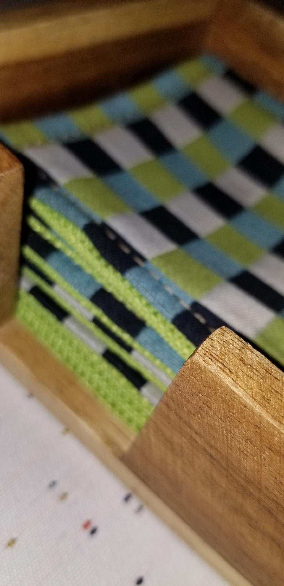 Modern square acacia wood coaster holder with black, white, lime green, and turquoise gingham check coaster. 