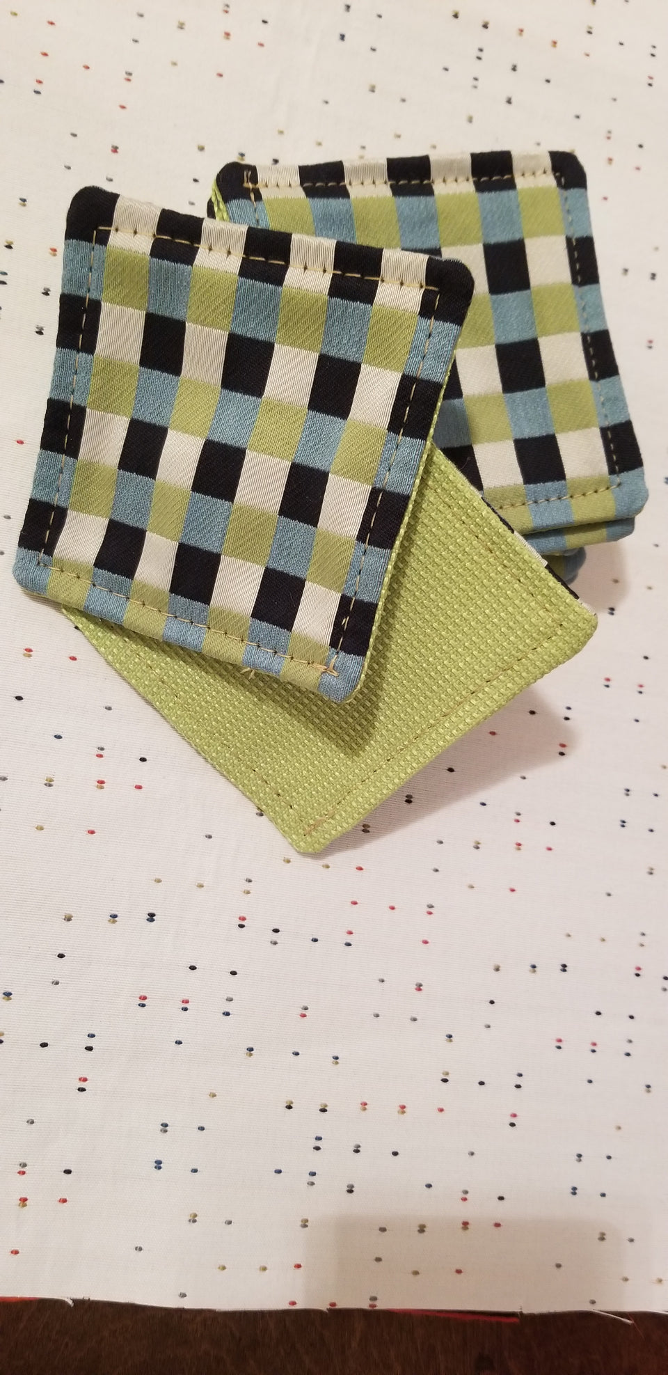 Chuck black, white, lime green, and turquoise gingham check patterned coasters front back detail top view.