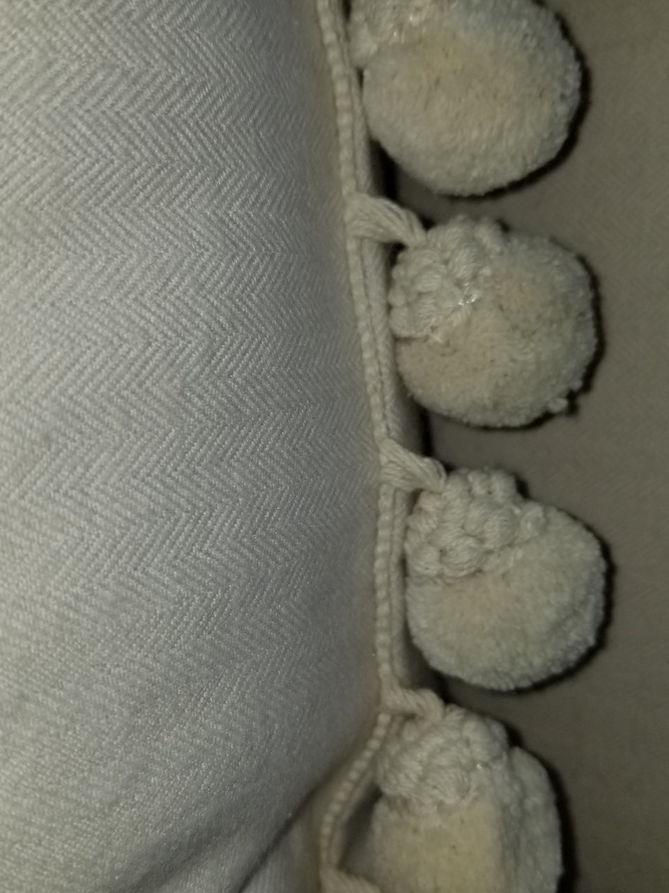 cream herringbone fleece fabric with gimp styled pom pom trim on a throw pillow cover detail