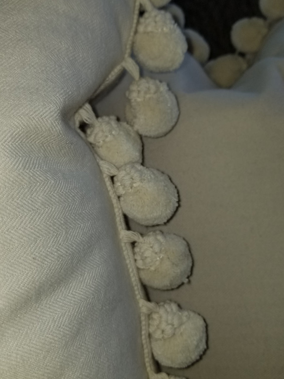 cream herringbone fleece fabric with gimp styled pom pom trim on a throw pillow cover