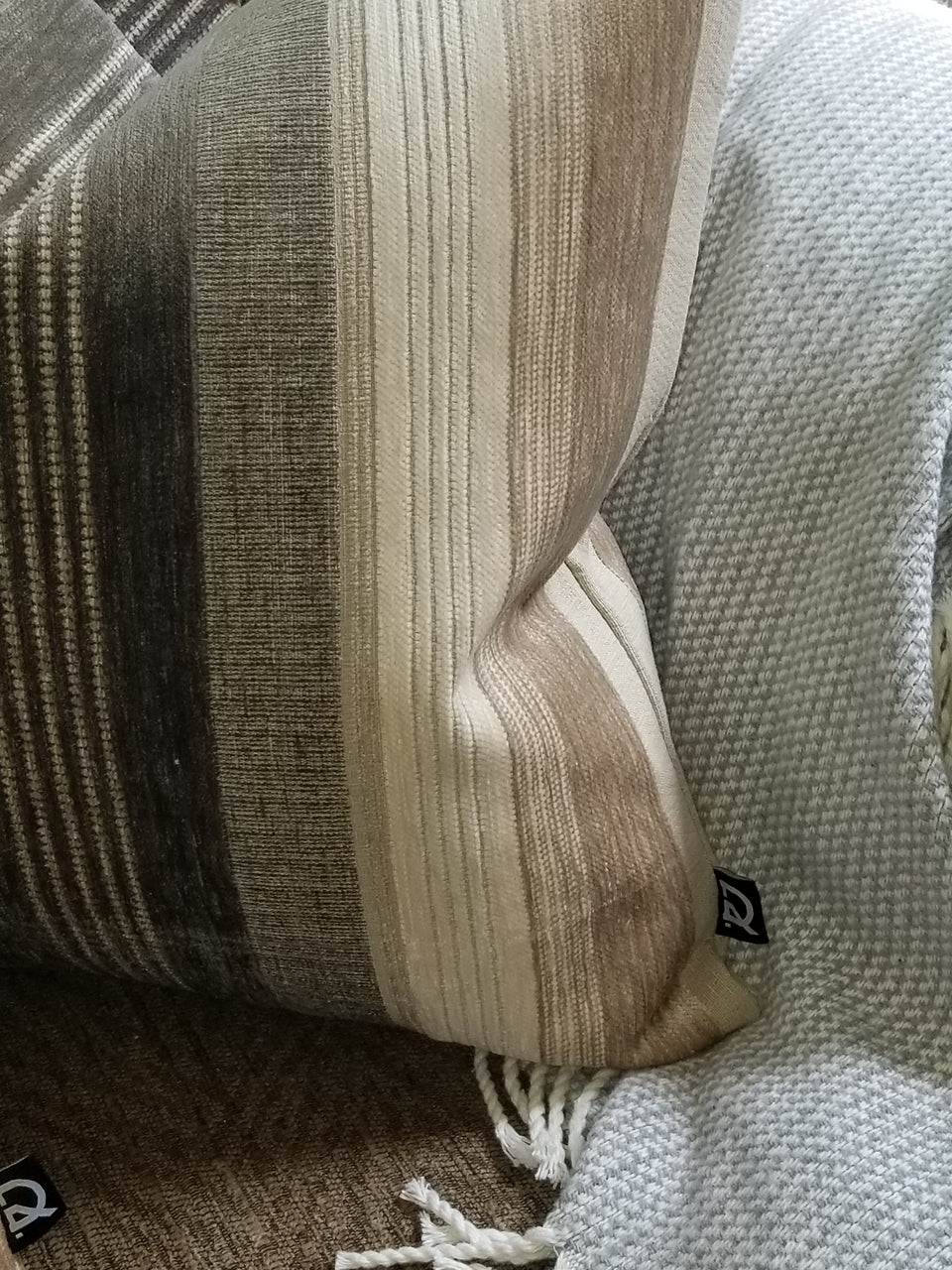 taupe and ivory velour stripe pillow covers on brown couch with taupe throw cover
